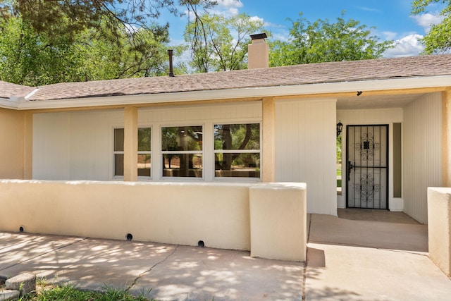 697 W W Meadowlark Ln, Corrales, NM 87048 - entrance to property with a chimney and a shingled roof
