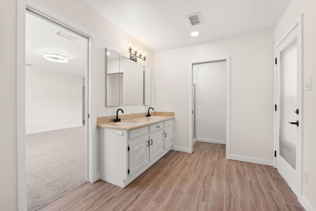 697 W W Meadowlark Ln, Corrales, NM 87048 - bathroom with double vanity, wood finished floors, and recessed lighting