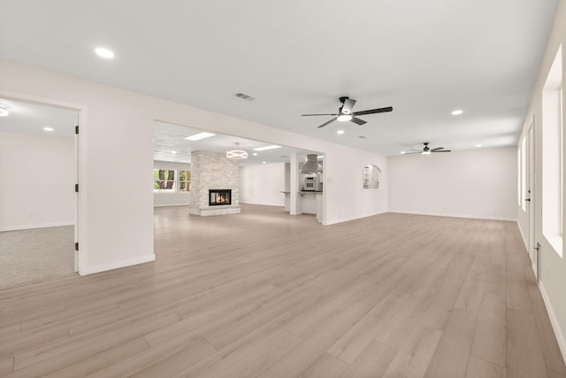 697 W W Meadowlark Ln, Corrales, NM 87048 - unfurnished living room with ceiling fan, recessed lighting, light wood-style flooring, and a fireplace