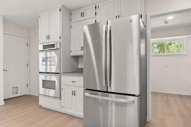 697 W W Meadowlark Ln, Corrales, NM 87048 - kitchen featuring appliances with stainless steel finishes, light wood-type flooring, white cabinetry, light stone countertops, and recessed lighting