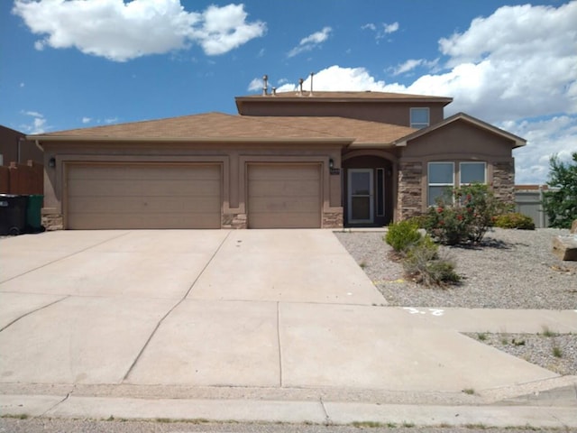 5485 Roosevelt Loop NE, Rio Rancho, NM 87144 - view of front of house featuring stone siding, a garage, concrete driveway, and stucco siding