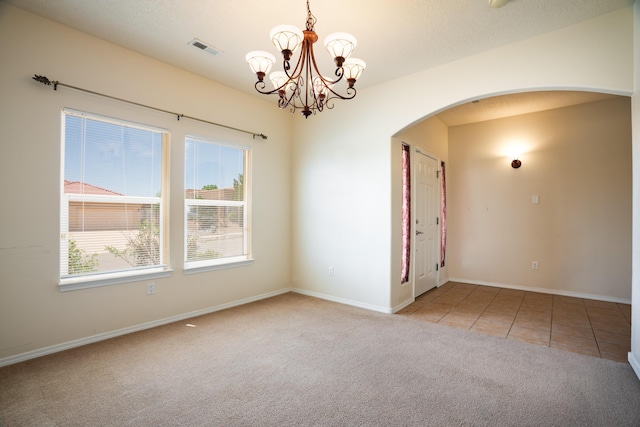 5485 Roosevelt Loop NE, Rio Rancho, NM 87144 - carpeted spare room featuring arched walkways, a chandelier, and tile patterned floors