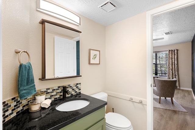 4432 La Paloma Rd NW, Albuquerque, NM 87120 - half bathroom featuring a textured ceiling, tasteful backsplash, wood finished floors, and vanity