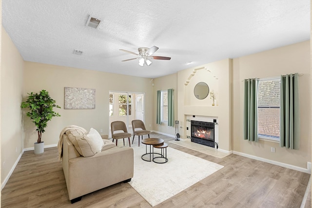4432 La Paloma Rd NW, Albuquerque, NM 87120 - living area featuring light wood-style floors, ceiling fan, a fireplace with flush hearth, and a textured ceiling