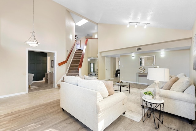 4432 La Paloma Rd NW, Albuquerque, NM 87120 - living room featuring stairway, high vaulted ceiling, and light wood-style floors