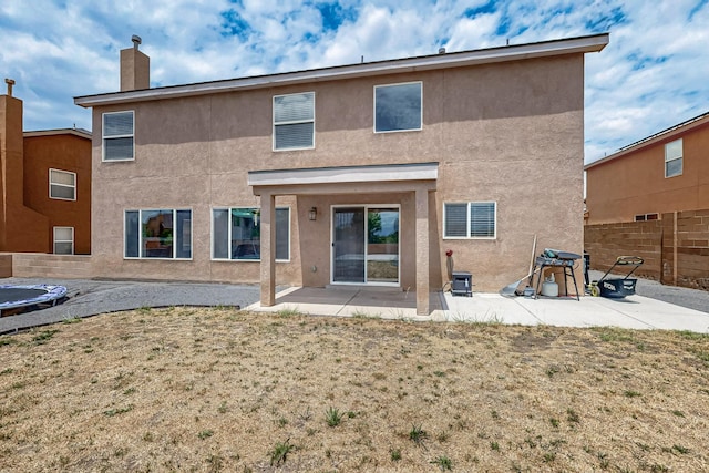 1191 Carrizo St NW, Los Lunas, NM 87031 - back of property featuring stucco siding, a patio, and a chimney