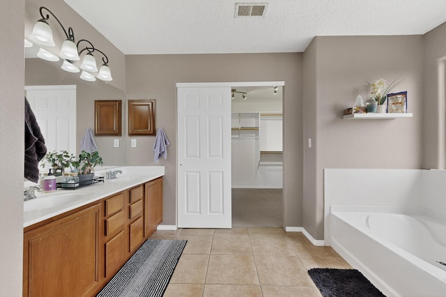 1191 Carrizo St NW, Los Lunas, NM 87031 - bathroom with double vanity, tile patterned flooring, a bath, and a spacious closet