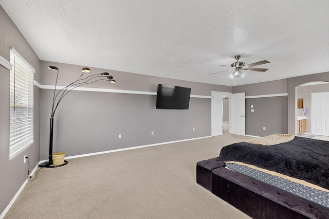 1191 Carrizo St NW, Los Lunas, NM 87031 - carpeted bedroom featuring a textured ceiling, arched walkways, and ceiling fan