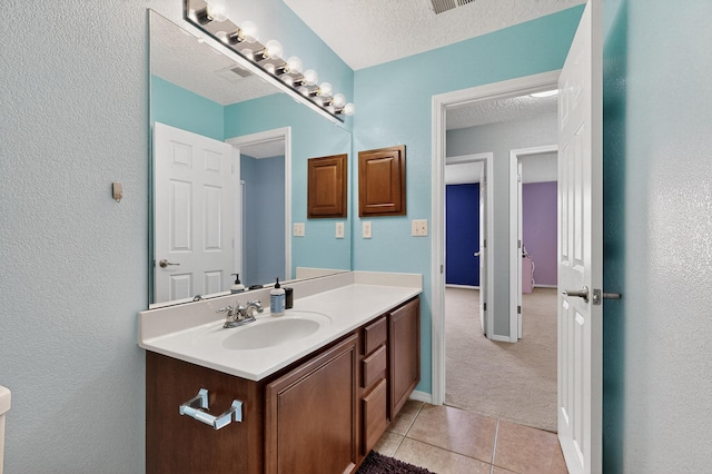 1191 Carrizo St NW, Los Lunas, NM 87031 - bathroom featuring vanity, a textured ceiling, tile patterned floors, and a textured wall
