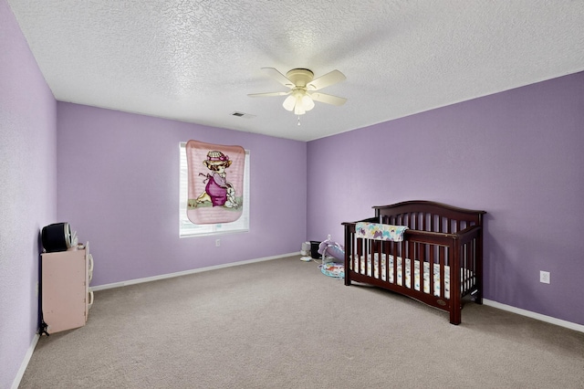 1191 Carrizo St NW, Los Lunas, NM 87031 - bedroom with carpet, a ceiling fan, a textured ceiling, and a nursery area