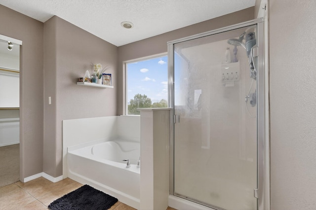 1191 Carrizo St NW, Los Lunas, NM 87031 - full bathroom featuring a stall shower, a bath, tile patterned floors, and a textured ceiling