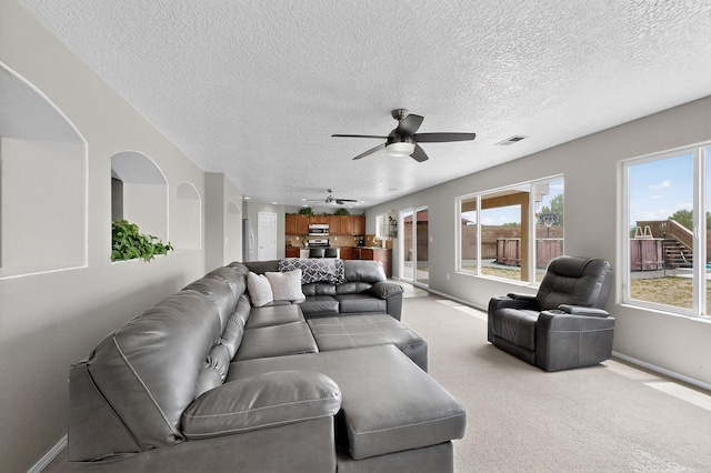 1191 Carrizo St NW, Los Lunas, NM 87031 - living room featuring ceiling fan, a textured ceiling, and light colored carpet