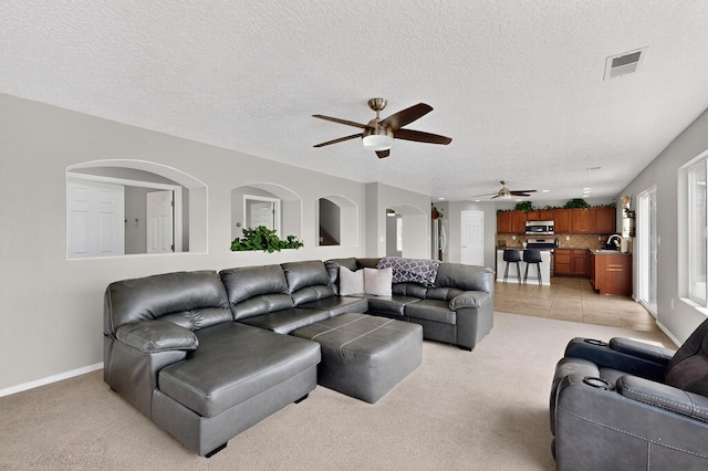 1191 Carrizo St NW, Los Lunas, NM 87031 - living room with light colored carpet, a ceiling fan, and a textured ceiling