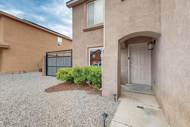 1191 Carrizo St NW, Los Lunas, NM 87031 - entrance to property featuring stucco siding and a gate