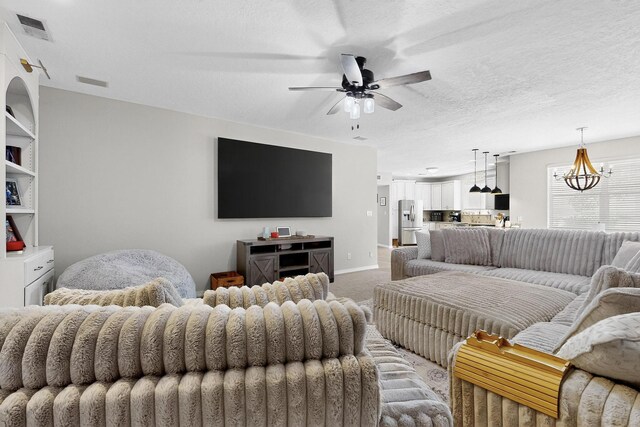 3546 Newcastle Dr SE, Rio Rancho, NM 87124 - living room featuring a ceiling fan, light colored carpet, and a chandelier
