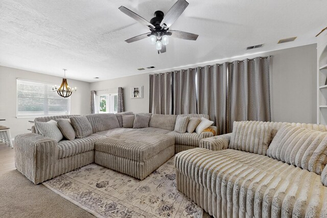 3546 Newcastle Dr SE, Rio Rancho, NM 87124 - living room featuring ceiling fan, a chandelier, and light carpet