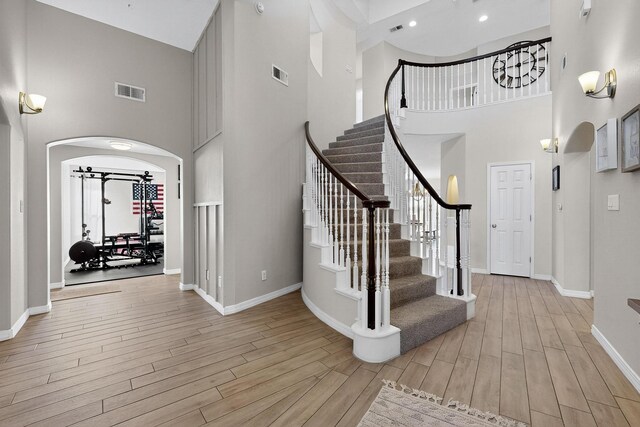 3546 Newcastle Dr SE, Rio Rancho, NM 87124 - stairway with a towering ceiling, wood finished floors, and arched walkways
