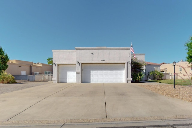 3546 Newcastle Dr SE, Rio Rancho, NM 87124 - pueblo-style house with an attached garage, stucco siding, and driveway