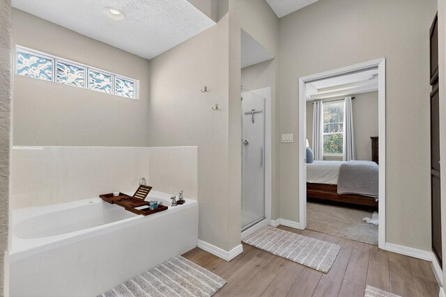 3546 Newcastle Dr SE, Rio Rancho, NM 87124 - full bathroom featuring a garden tub, a shower stall, wood finished floors, and ensuite bath