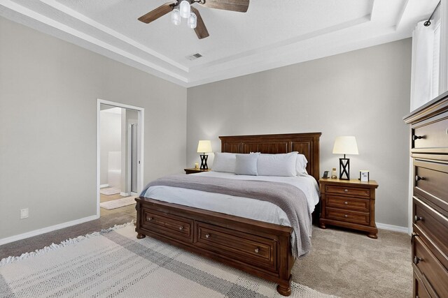 3546 Newcastle Dr SE, Rio Rancho, NM 87124 - bedroom featuring light carpet, a tray ceiling, connected bathroom, and a ceiling fan
