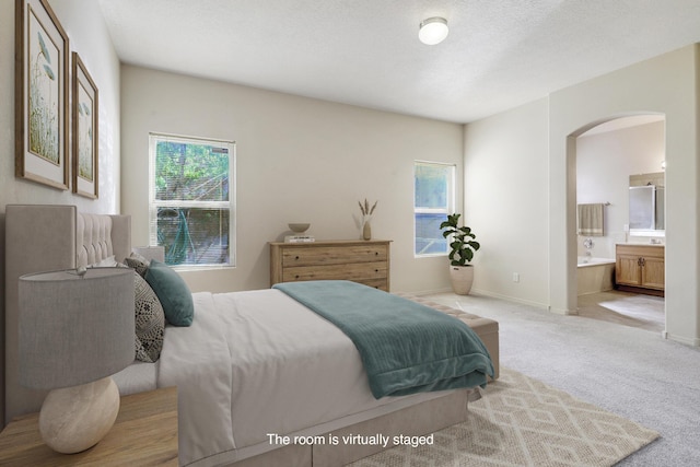 1852 Smarty Jones St SE, Albuquerque, NM 87123 - bedroom featuring arched walkways, carpet, and connected bathroom
