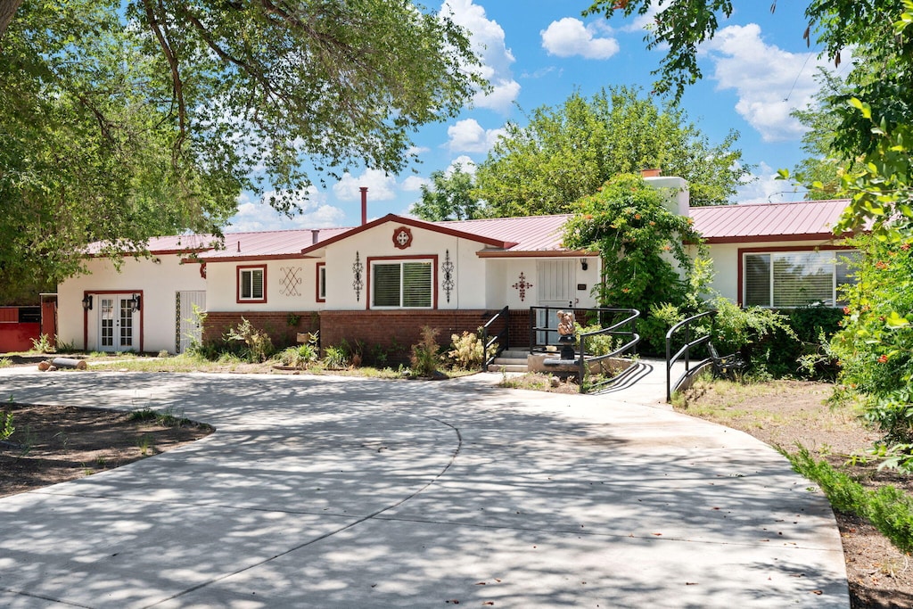 2244 Theresa Rd SW, Albuquerque, NM 87105 - single story home with french doors, a metal roof, brick siding, stucco siding, and a chimney