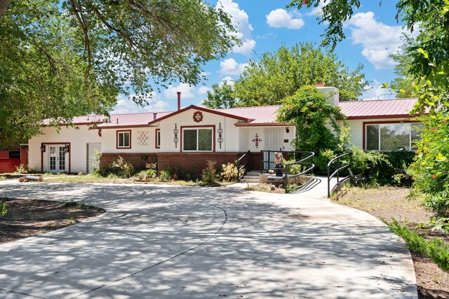 2244 Theresa Rd SW, Albuquerque, NM 87105 - single story home with french doors, a metal roof, brick siding, stucco siding, and a chimney