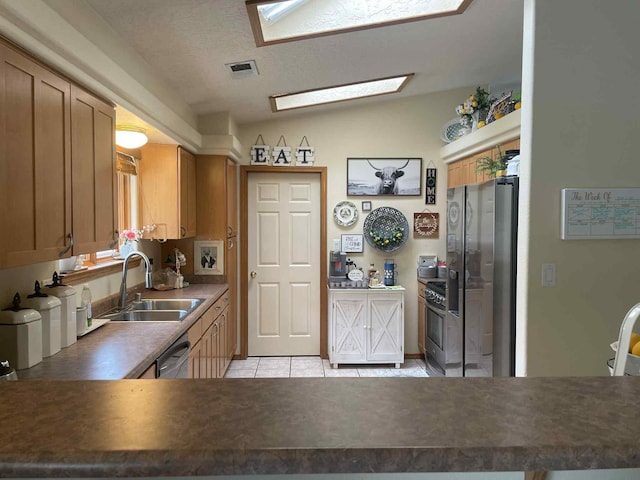 34358 US Highway 285, Ojo Caliente, NM 87549 - kitchen featuring light tile patterned floors, stainless steel appliances, dark countertops, and brown cabinets
