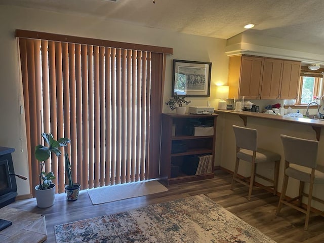 34358 US Highway 285, Ojo Caliente, NM 87549 - kitchen featuring wood finished floors, a wood stove, and a textured ceiling