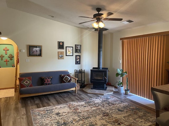 34358 US Highway 285, Ojo Caliente, NM 87549 - living area featuring a ceiling fan, wood finished floors, a wood stove, and arched walkways