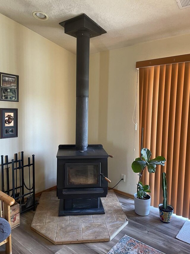 34358 US Highway 285, Ojo Caliente, NM 87549 - detailed view of a textured ceiling, wood finished floors, and a wood stove