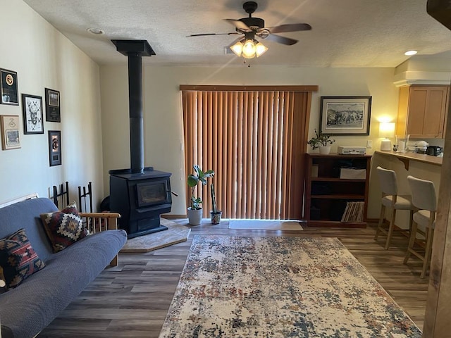 34358 US Highway 285, Ojo Caliente, NM 87549 - living room with a wood stove, ceiling fan, dark wood-style floors, and a textured ceiling