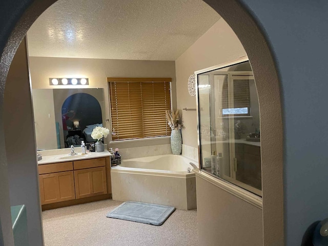34358 US Highway 285, Ojo Caliente, NM 87549 - ensuite bathroom with a garden tub, a shower stall, vanity, and a textured ceiling