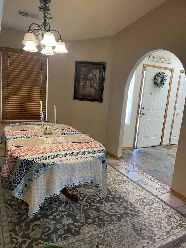 34358 US Highway 285, Ojo Caliente, NM 87549 - dining space with arched walkways, a chandelier, and stone tile flooring