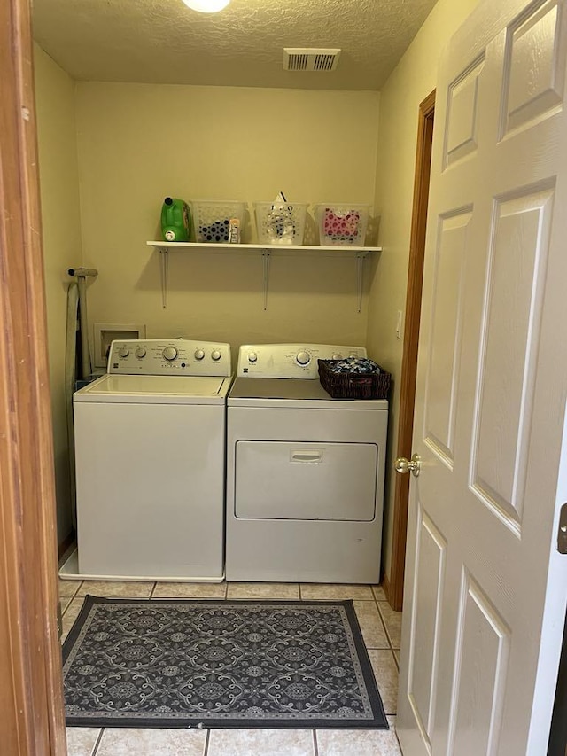 34358 US Highway 285, Ojo Caliente, NM 87549 - laundry room featuring washer and clothes dryer, light tile patterned flooring, and a textured ceiling