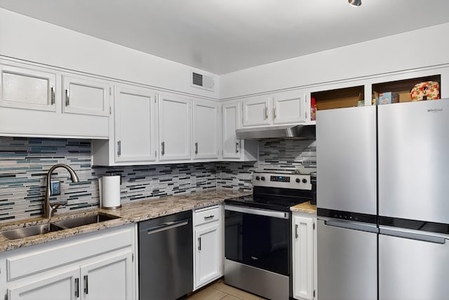 1308 Boatright Dr NE, Albuquerque, NM 87112 - kitchen featuring appliances with stainless steel finishes, under cabinet range hood, white cabinets, tasteful backsplash, and light stone countertops