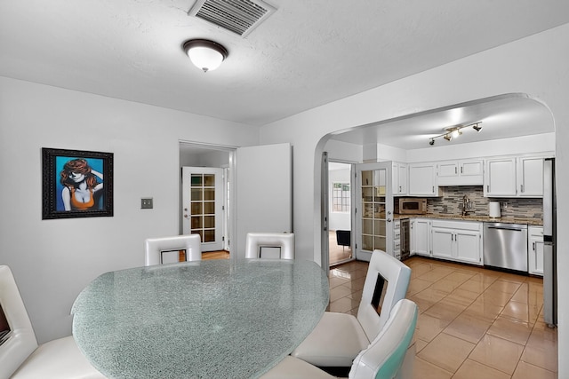 1308 Boatright Dr NE, Albuquerque, NM 87112 - dining room featuring arched walkways, light tile patterned floors, and beverage cooler