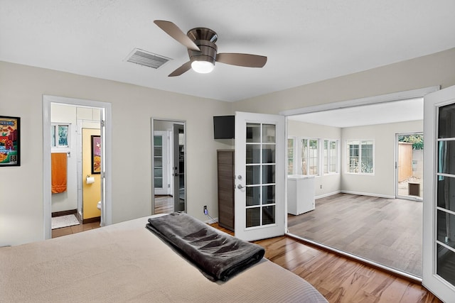 1308 Boatright Dr NE, Albuquerque, NM 87112 - bedroom with wood finished floors, connected bathroom, a ceiling fan, and french doors