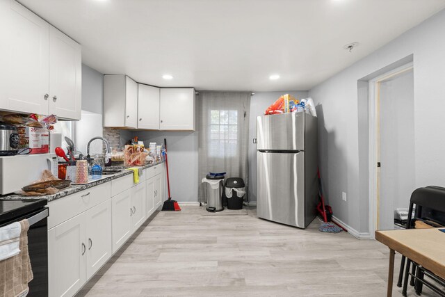 2024 Hinkle St SE, Albuquerque, NM 87102 - kitchen featuring freestanding refrigerator, range with electric stovetop, white cabinetry, light wood-style flooring, and stone counters
