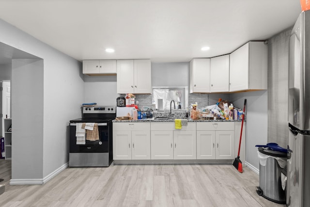 2024 Hinkle St SE, Albuquerque, NM 87102 - kitchen with stainless steel appliances, light wood-type flooring, white cabinets, backsplash, and stone countertops