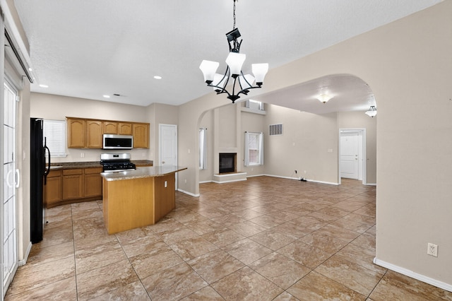5508 Carefree Ave NW, Albuquerque, NM 87120 - kitchen with appliances with stainless steel finishes, arched walkways, a center island, open floor plan, and recessed lighting
