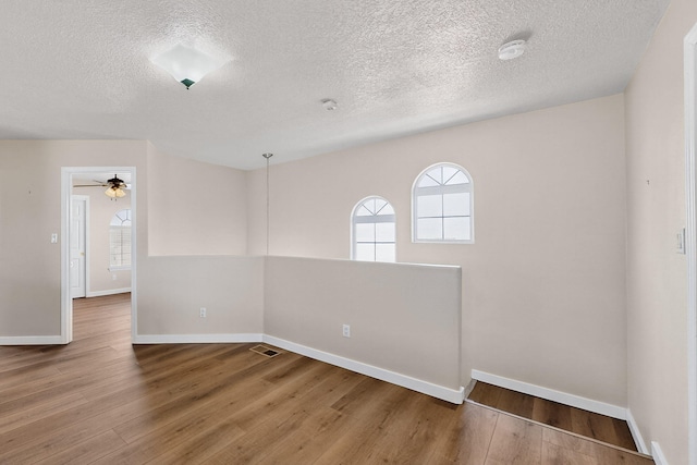 5508 Carefree Ave NW, Albuquerque, NM 87120 - spare room with a textured ceiling, wood finished floors, a ceiling fan, and a smoke detector