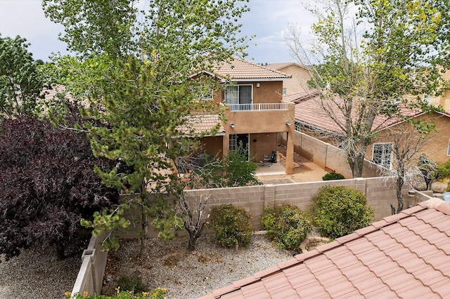 5508 Carefree Ave NW, Albuquerque, NM 87120 - back of house featuring a tile roof, a balcony, a patio, a fenced backyard, and stucco siding
