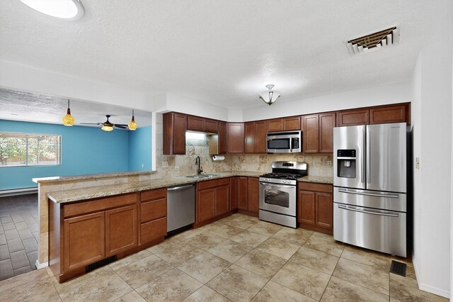 12208 Phoenix Ave NE, Albuquerque, NM 87112 - kitchen with appliances with stainless steel finishes, a peninsula, decorative backsplash, light stone countertops, and a ceiling fan