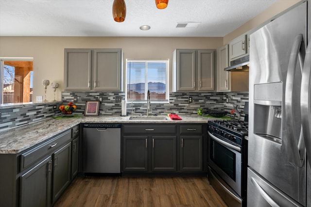 5478 Salem Ct NE, Rio Rancho, NM 87144 - kitchen with appliances with stainless steel finishes, under cabinet range hood, a peninsula, backsplash, and dark wood-type flooring
