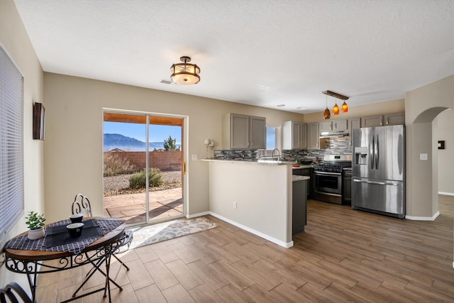 5478 Salem Ct NE, Rio Rancho, NM 87144 - kitchen with appliances with stainless steel finishes, gray cabinets, dark wood-type flooring, backsplash, and a textured ceiling