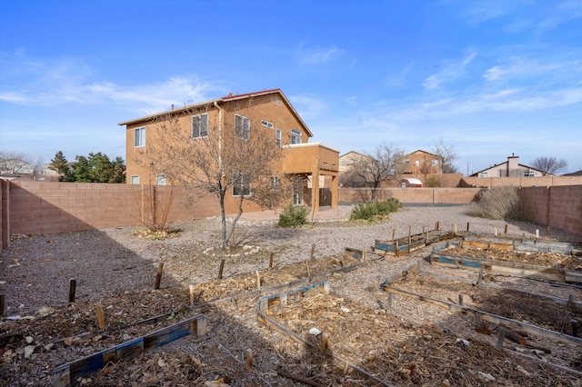 5478 Salem Ct NE, Rio Rancho, NM 87144 - back of property with a vegetable garden, a fenced backyard, and stucco siding