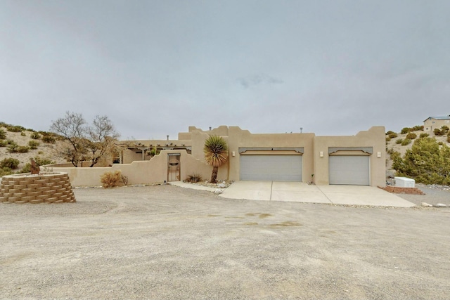 39 Pine Rd, Placitas, NM 87043 - view of front of house with concrete driveway, a garage, stucco siding, and a gate