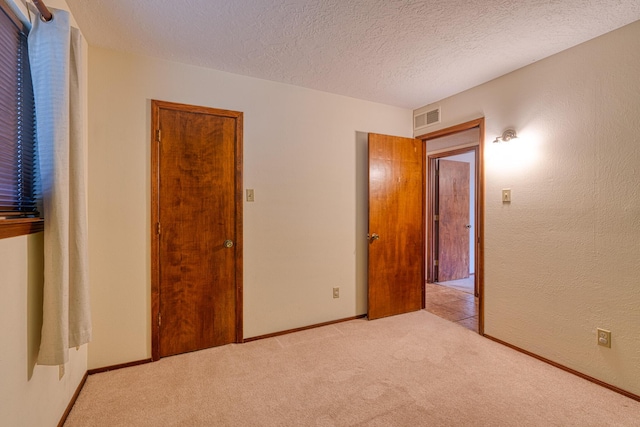9201 Academy Hills Dr NE, Albuquerque, NM 87111 - unfurnished bedroom featuring light carpet and a textured ceiling
