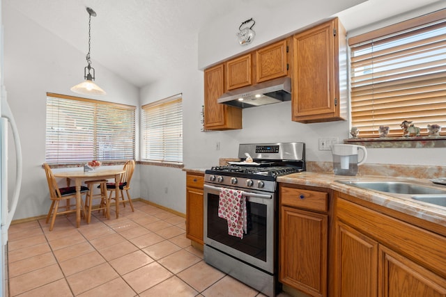 7824 Snowberry St NW, Albuquerque, NM 87120 - kitchen with under cabinet range hood, gas stove, lofted ceiling, light tile patterned flooring, and light countertops